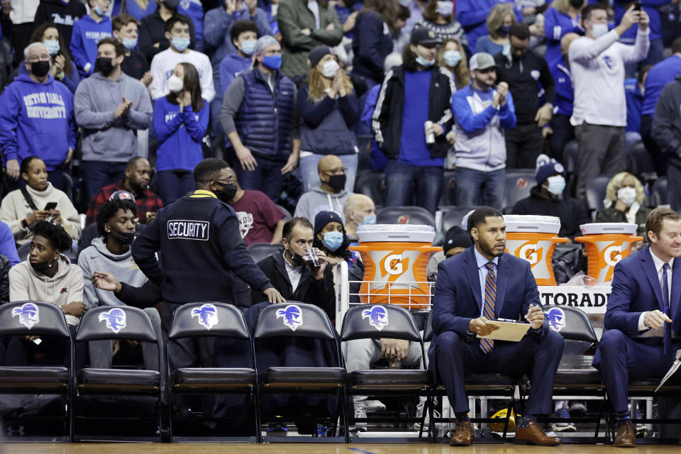 Seton Hall assistant coach Marcus Mathews sits on an empty bench during the first half of an NCAA college basketball game against Villanova on Saturday, Jan. 1, 2022, in Newark, N.J. Seton Hall played the game with 8 players. (AP Photo/Adam Hunger)