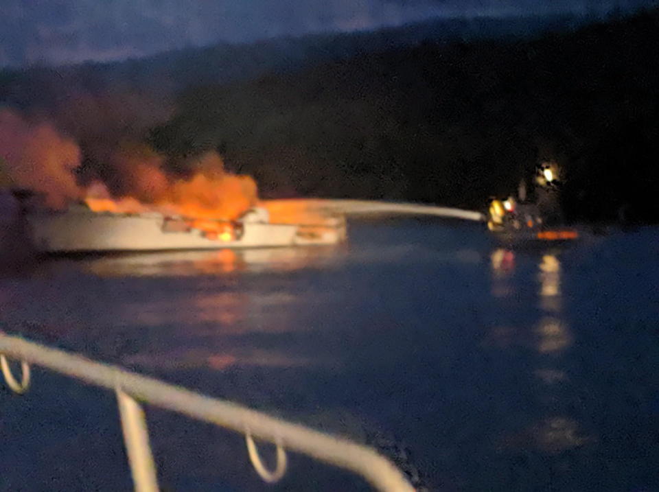 The Conception on fire off the north side of Santa Cruz Island, California on September 2. A fire fighter is seen spraying it with a hose.