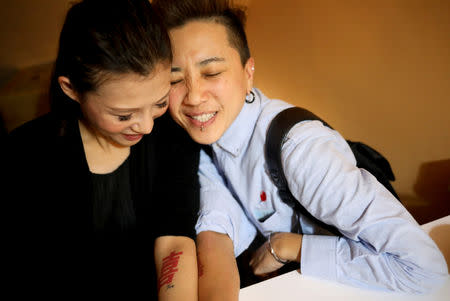 Du Yueting (R), 42, and her girlfriend Zhang Tongyu, 35, pose for a photograph at their restaurant after a long day of work, in New Taipei City, Taiwan, November 20, 2018. REUTERS/Ann Wang