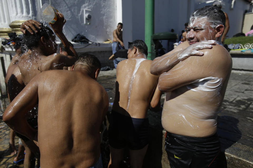 Central American migrants making their way to the U.S. in a large caravan bathe using water from a fire hydrant at the main plaza in Tapachula, Mexico, Monday, Oct. 22, 2018. Thousands of Central American migrants hoping to reach the U.S. were deciding Monday whether to rest in this southern Mexico town or resume their arduous walk through Mexico as President Donald Trump rained more threats on their governments. (AP Photo/Moises Castillo)