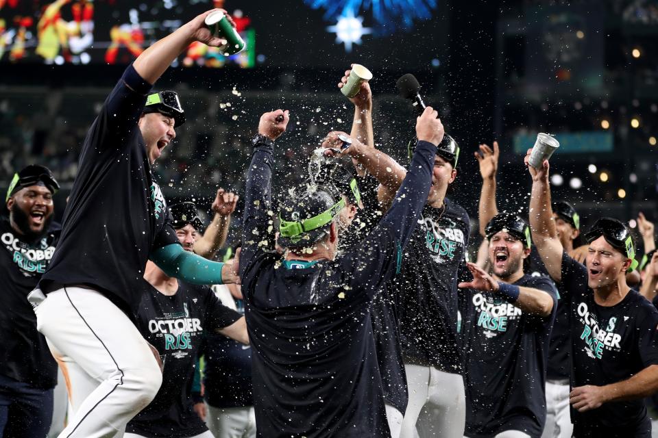 SEATTLE, WASHINGTON - SEPTEMBER 30: Manager Scott Servais #9 of the Seattle Mariners celebrates after clinching a postseason birth after beating the Oakland Athletics 2-1 at T-Mobile Park on September 30, 2022 in Seattle, Washington. The Seattle Mariners have clinched a postseason appearance for the first time  in 21 years, the longest playoff drought in North American professional sports. (Photo by Steph Chambers/Getty Images)