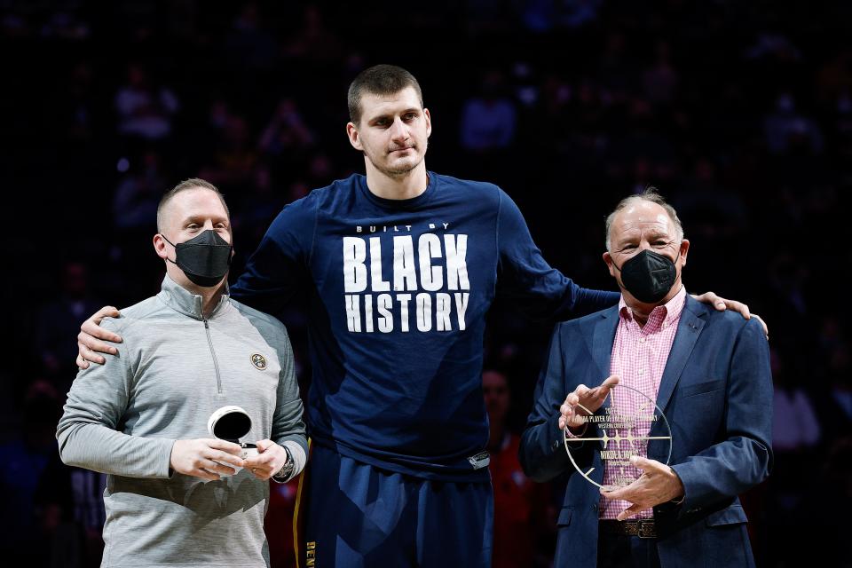 Denver Nuggets center Nikola Jokic (center) is presented with an NBA All-Star ring from Nuggets president Tim Connelly (left) and player of the month award from a KIA representative (right) before the game against the Orlando Magic at Ball Arena on Feb. 14, 2022, in Denver, Colorado.