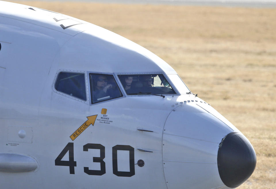 FILE - In this April 5, 2014 file photo, pilots look out of a window from the cockpit in a U.S. Navy P-8 Poseidon plane as it taxies to the end of the runway to take off from Perth Airport on route to conduct search operations for missing Malaysia Airlines Flight MH370 in southern Indian Ocean, near the coast of Western Australia. Every day from the Perth airport and a nearby military base, about a dozen planes from several countries take flight to search for debris from missing Flight 370 _ so far without success. The U.S. Defense Department alone committed $7.3 million to the effort in the first month of the search, much of it spent on two U.S. Navy P-8 Poseidon planes that cost $4,000 per hour to fly. (AP Photo/Rob Griffith, File)