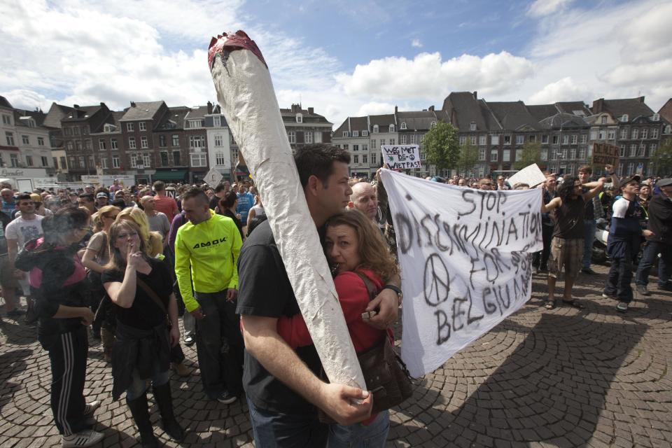 A demonstrator carrying a larger-than-life mock marijuana joint attends a protest rally against the new marijuana buying policy in Maastricht, southern Netherlands, Tuesday May 1, 2012. A policy barring foreign tourists from buying marijuana in the Netherlands goes into effect in parts of the country Tuesday, with a protest planned in the southern city of Maastricht. Weed is technically illegal in the Netherlands, but it is sold openly in small amounts in designated cafes under the country's famed tolerance policy. The government has said that as of May 1, only holders of a "weed pass" will be allowed to purchase the drug, and nonresidents aren't eligible. (AP Photo/Peter Dejong)