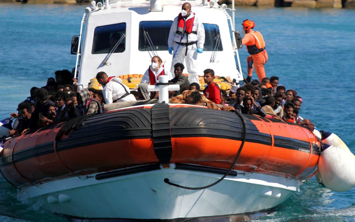 Migrants aboard a search-and-rescue boat approaching the island of Lampedusa - Reuters