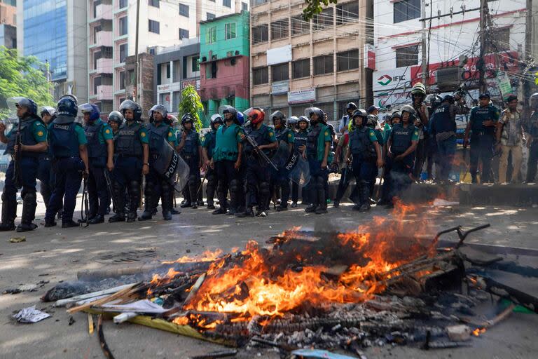 La policía bangladesí enfrenta fogatas armadas por los manifestantes (Photo by Abdul Goni / AFP)