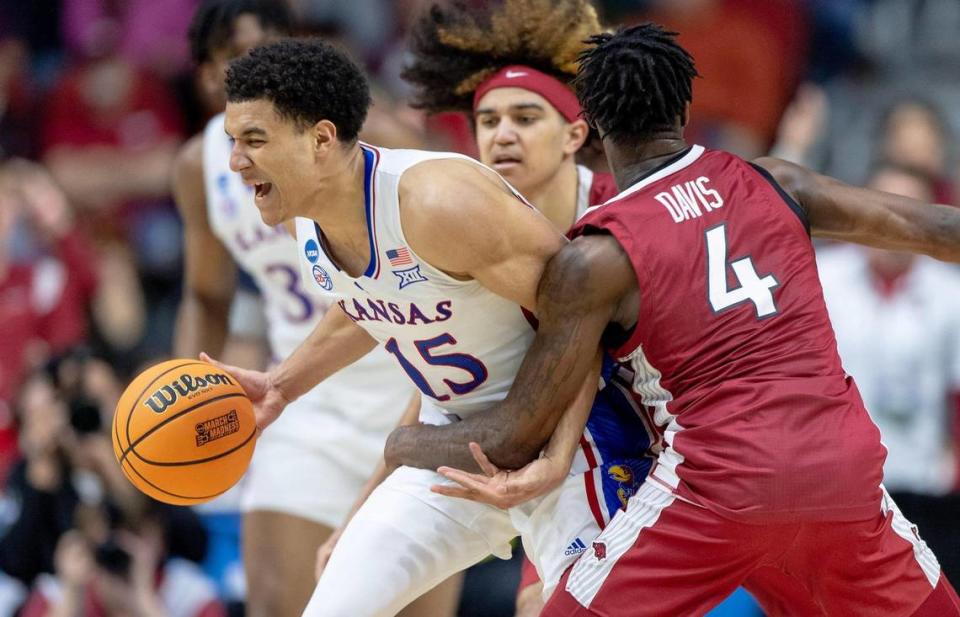 Arkansas guard Davonte Davis (4) fouls Kansas guard Kevin McCullar Jr. (15) during a second-round college basketball game in the NCAA Tournament Saturday, March 18, 2023, in Des Moines, Iowa.