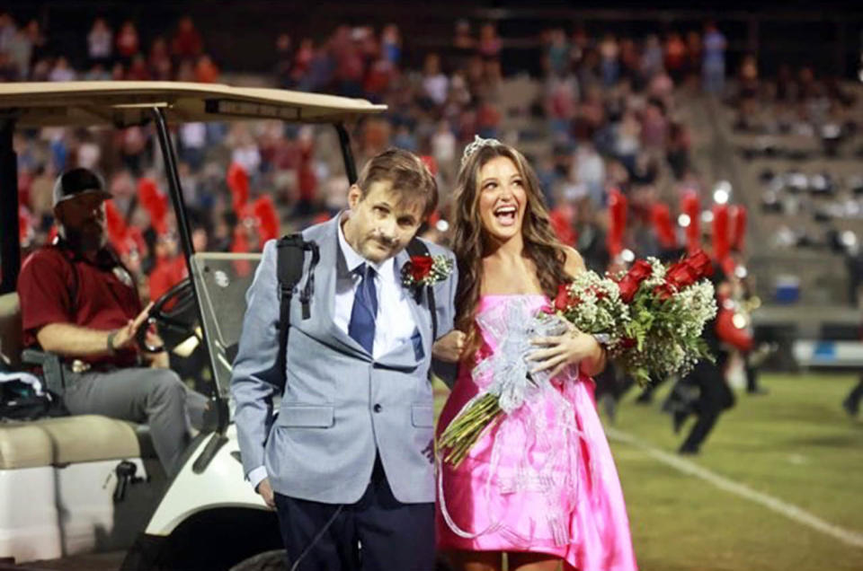 During his walk across the football field, Brett Yancey held tight to his daughter, Sara Kate, to keep steady. There wasn't a dry eye after he made the trek.  (Courtesy Breahna Light)