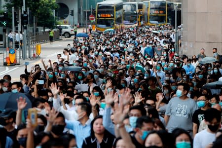 Anti-government office workers wearing masks attend a lunch time protest, after local media reported on an expected ban on face masks under emergency law, at Central, in Hong Kong