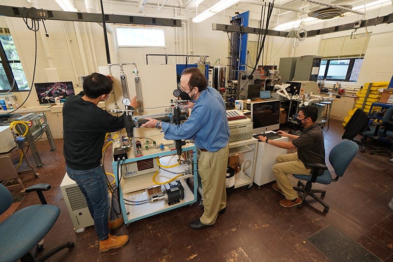 Purdue professor Issam Mudawar (center) and his students work on a new charging cable design that could reduce charging times for electric vehicles to under five minutes. (Purdue University photo/Jared Pike)