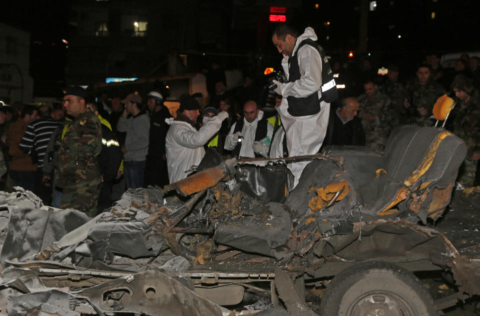 Lebanese investigators inspect damages after a suicide bomber blew himself up in a passenger van in the Choueifat district southern Beirut, Lebanon, Monday, Feb. 3, 2014. A suicide bomber blew himself up in the southern suburbs of the Lebanese capital Monday, wounding at least six people, the state news agency said. The blast, which took place during the evening rush hour in the Choueifat district, appeared to be the latest of a string of attacks in Lebanon linked to the civil war in neighboring Syria. The conflict has deeply divided Lebanon along sectarian lines and helped fuel a surge in violence that has rattled the already fragile country. (AP Photo/Bilal Hussein)
