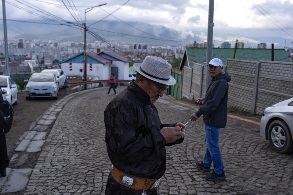 A Mongolian man prepares to smoke after voting at a polling station in Ger district on the outskirts of Ulaanbaatar, Mongolia, Friday, June 28, 2024. (AP Photo/Ng Han Guan)