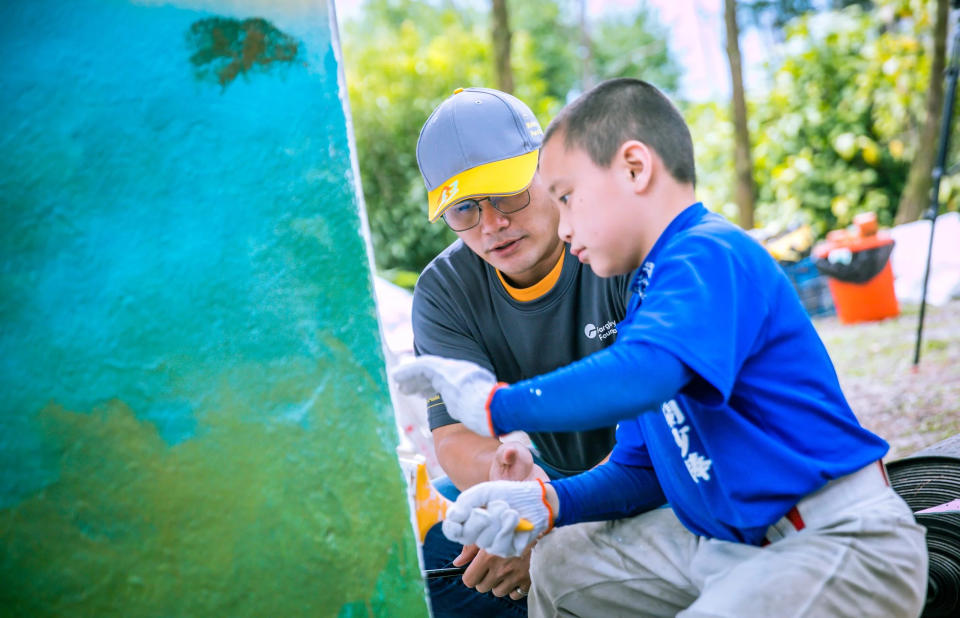 「大隊長」楊聖均與小球員一起彩繪外牆，分享棒球策略、技巧