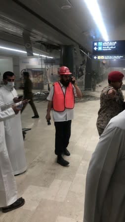 Rescue workers and civilians are seen at Saudi Arabia's Abha airport after it was attacked by Yemen's Houthi groupin in Abha