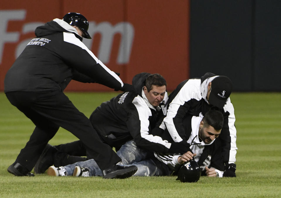 Security officers apprehend a fan that ran on the field during the fifth inning of a game between the Chicago White Sox and the Boston Red Sox at Guaranteed Rate Field on May 04, 2019 in Chicago, Illinois. (Photo by David Banks/Getty Images)