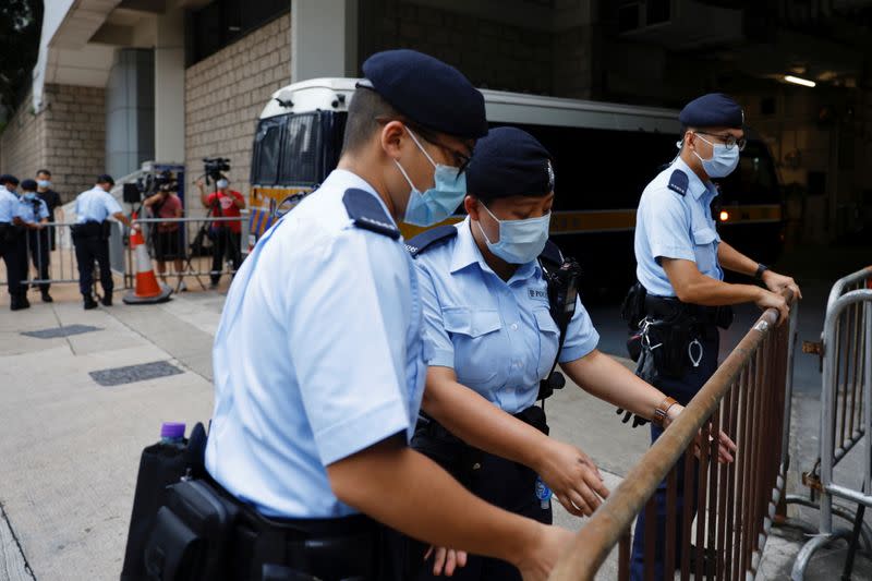 Police stand guards as a prison van arrive High Court on the first day of trial of Tong Ying-kit, the first person charged under a new national security law, in Hong Kong