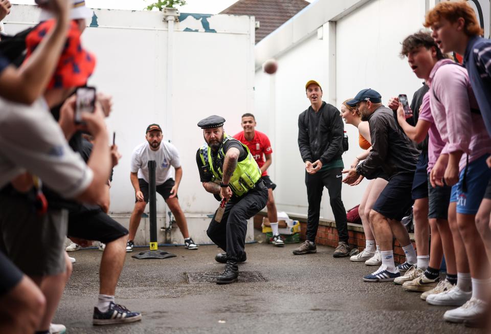 A Policeman joins in a game of cricket under the Western Terrace during a rain delayed Day Three (Getty Images)