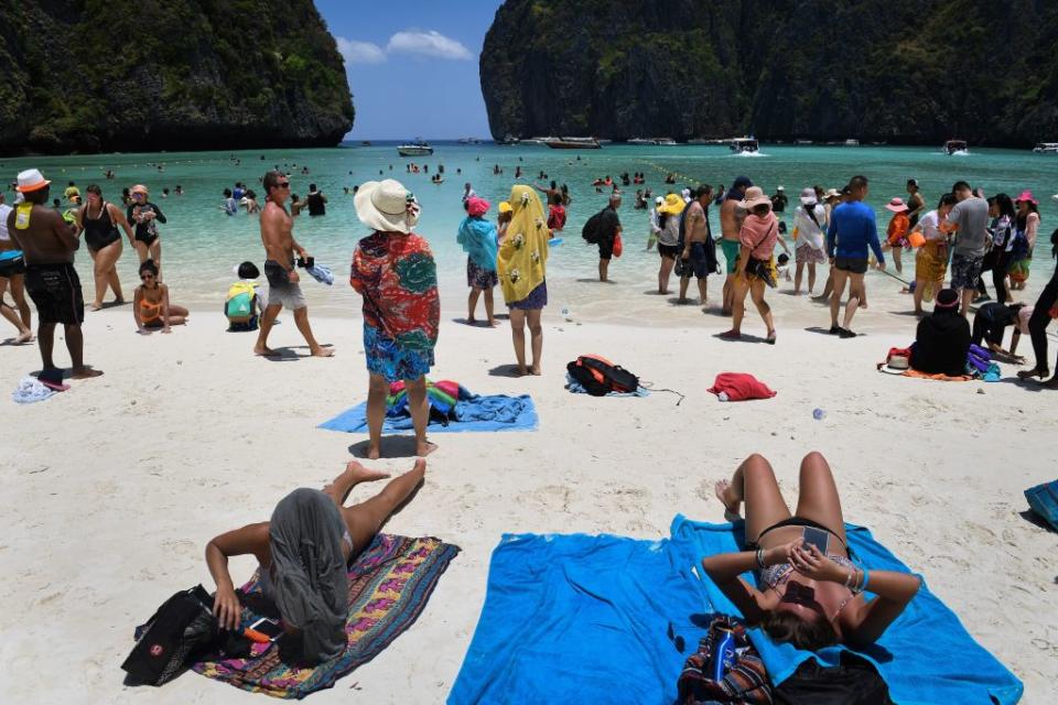 This photo taken on April 9, 2018 shows tourists sunbathing and walking on Maya Bay, Phi Phi, Thailand<span class="copyright">LILLIAN SUWANRUMPHA/AFP via Getty Images</span>