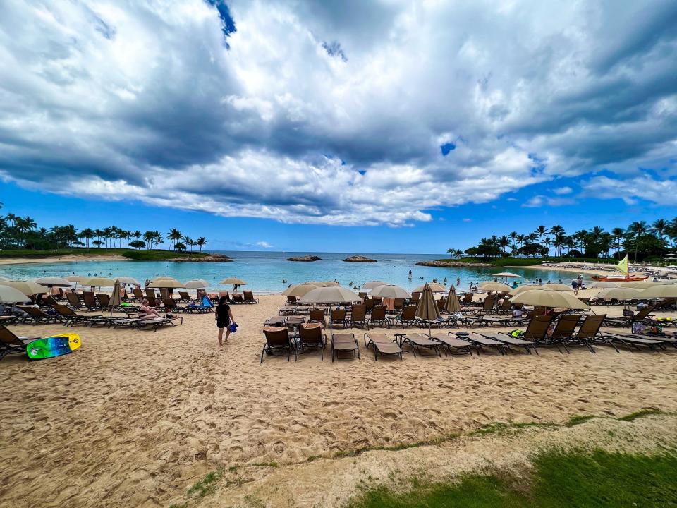 Rows of beach chairs and umbrellas facing a calm tropical beach.