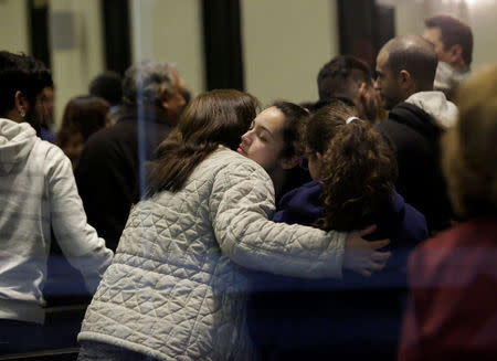 People hug during a mass at a local church after a teenage student shot several students and a teacher at the private school Colegio Americano del Noreste before killing himself, in Monterrey, Mexico, January 18, 2017. REUTERS/Daniel Becerril