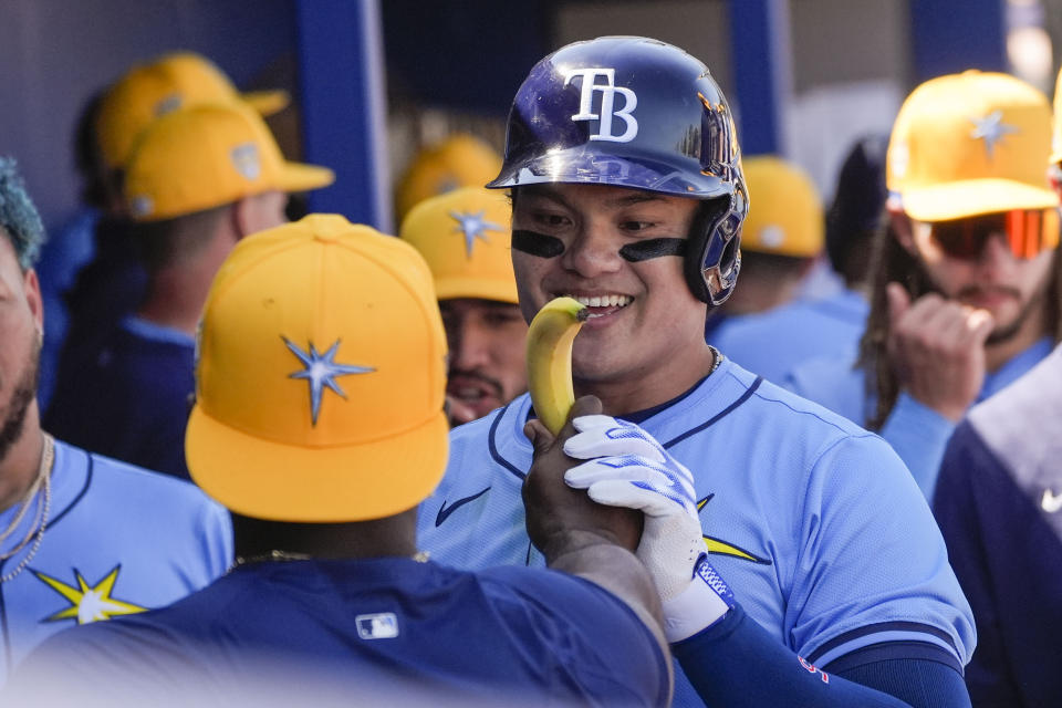 Tampa Bay Rays Yu Chang is is presented a banana in the dugout after his home run in the second inning of a spring training baseball game against the Detroit Tigers in Port Charlotte, Fla., Sunday, Feb. 25, 2024. (AP Photo/Gerald Herbert)