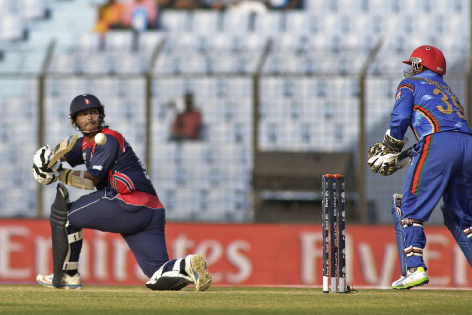 Nepal's Subash Khakurel plays a shot as Afghanistan's wicketkeeper Mohammad Shahzad, right, watches during their ICC Twenty20 Cricket World Cup match in Chittagong, Bangladesh, Thursday, March 20, 2014 . (AP Photo/Bikas Das)