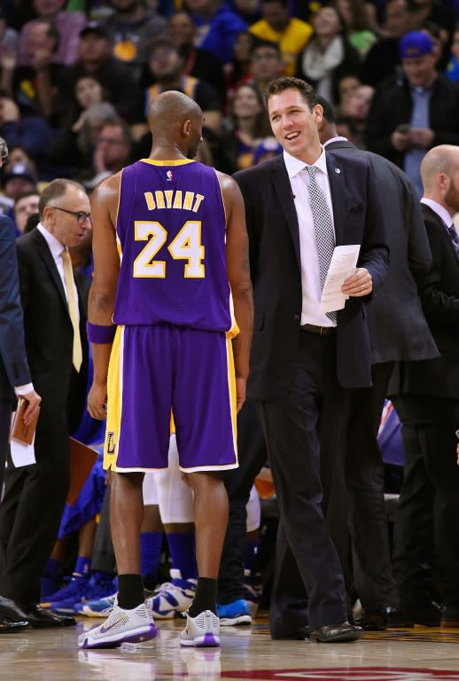 Kobe Bryant (L) of the Los Angeles Lakers during a time out talks with Golden State Warriors interim head coach Luke Walton on November 24, 2015 in Oakland, California