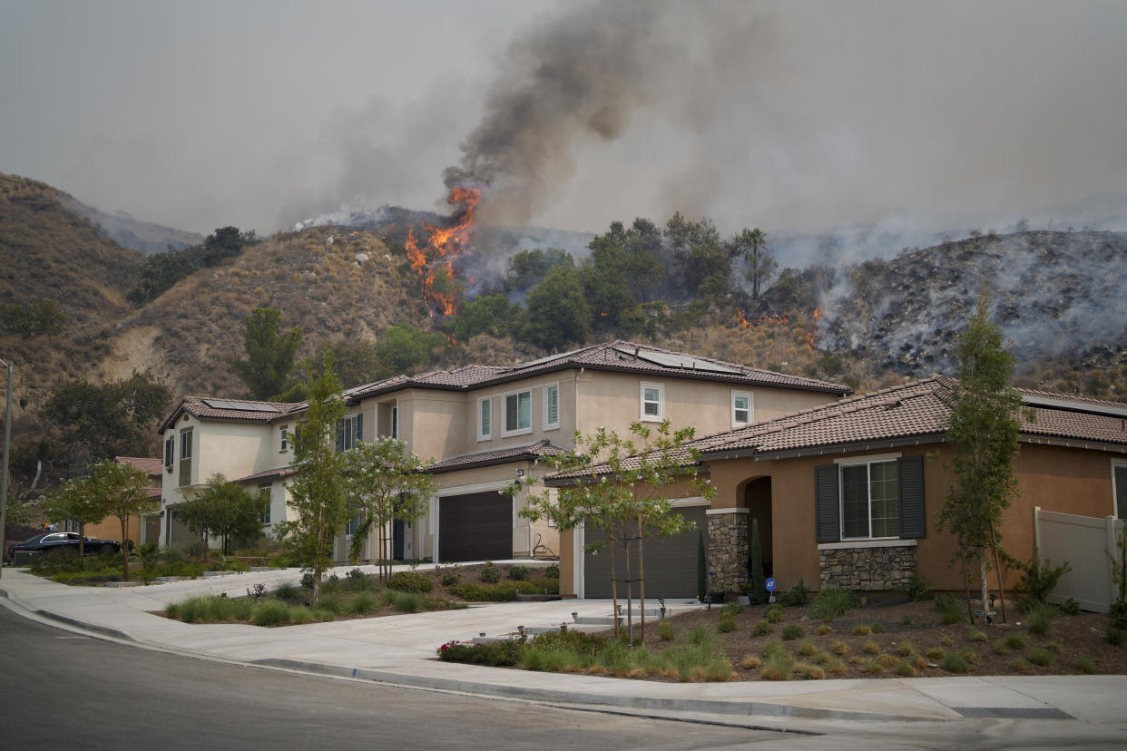 Flames seen behind a home.