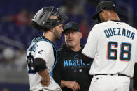 Miami Marlins pitching coach Mel Stottlemyre, center, talks to catcher Jacob Stallings (58) and relief pitcher Johan Quezada (68) during the eighth inning of a baseball game against the Atlanta Braves, Tuesday, May 2, 2023, in Miami. The Braves defeated the Marlins 6-0. (AP Photo/Marta Lavandier)