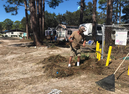 A man cleans debris and seaweed after the passing of Hurricane Michael at a holiday campground off Ocklockonee Bay in Panacea, Florida, U.S. October 12, 2018. REUTERS/Devika Krishna Kumar