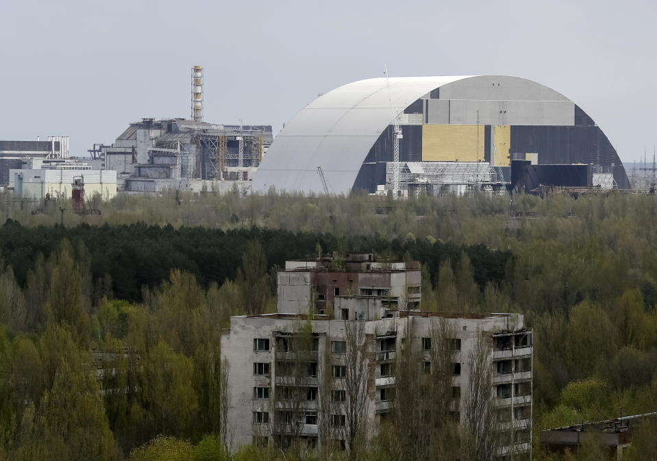 A containment shelter for the damaged fourth reactor (L) and the New Safe Confinement (NSC) structure (R) at the Chernobyl Nuclear Power Plant are seen from Ukraine's abandoned town of Pripyat, Ukraine, April 22, 2016.  REUTERS/Gleb Garanich      TPX IMAGES OF THE DAY     