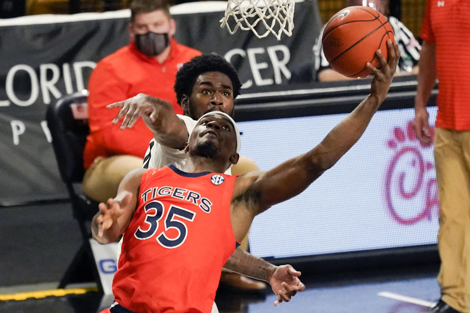 Auburn guard Devan Cambridge (35) goes in for a shot in front of Central Florida guard Dre Fuller Jr. during the second half of an NCAA college basketball game, Monday, Nov. 30, 2020, in Orlando, Fla. (AP Photo/John Raoux)