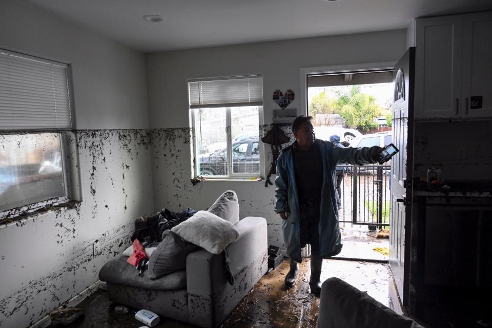 Tony Blas points to the water line inside his home that flooded during a rain storm Monday, Jan. 22, 2024, in San Diego, California.