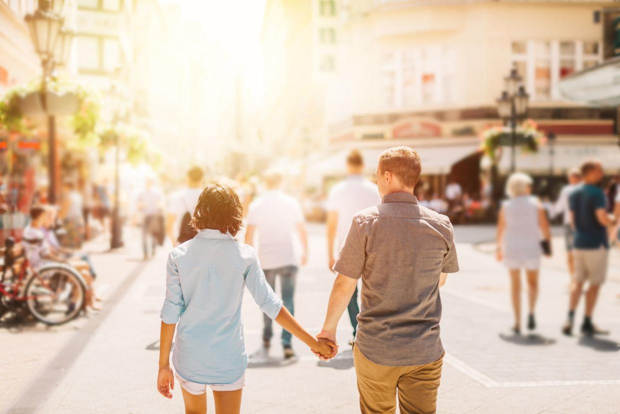 Multicultural Happy Couple Tourists Walking Down The Streets Of Budapest Hungary, Holding Hands