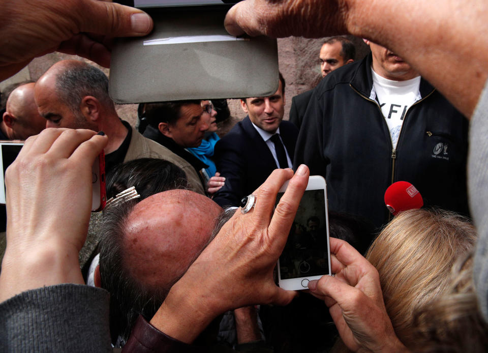 <p>French independent centrist presidential candidate Emmanuel Macron, rear at center, meets residents in Rodez, southern France, Friday, May 5, 2017. The 39-year-old independent candidate faces far-right National Front leader Marine Le Pen in Sunday’s presidential runoff. (AP Photo/Christophe Ena) </p>