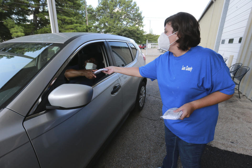 Dana Renner continues to hand out five pack bags of masks to residents Tuesday, July 14, 2020, at the Lee County Multipurpose Center in Tupelo, Mississippi. The center has over 16,000 masks to give and will continue the give away each day from 8 a.m. to 2 p.m. through Thursday. This give-away is in response to the county seat, Tupelo, now requiring masks inside businesses and other buildings open to the public.(Thomas Wells/Northeast Mississippi Daily Journal, Via AP)