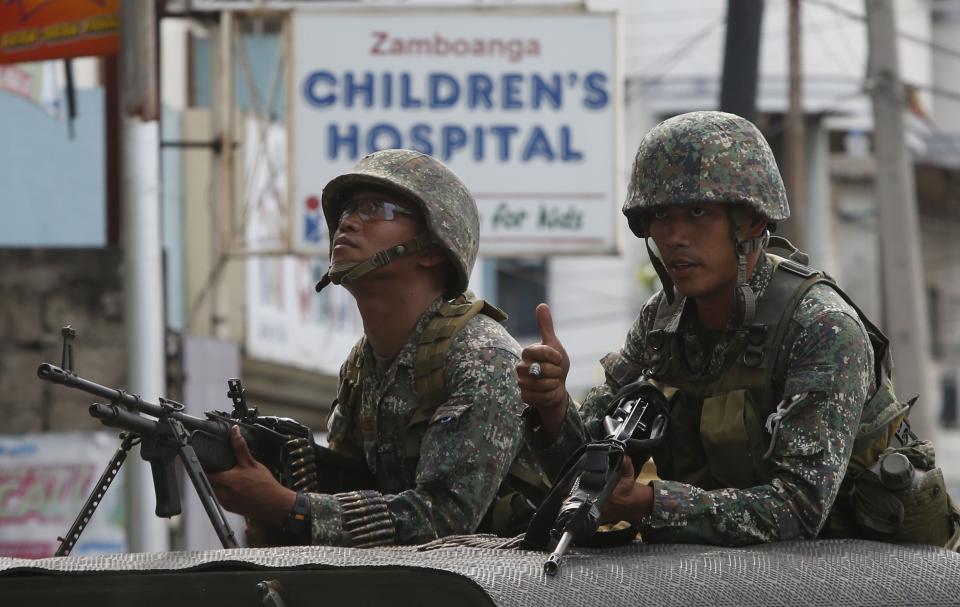 Members of the Philippine marines hold their weapons aboard a truck as they block a road during fighting between government soldiers and Muslim rebels of MNLF in Zamboanga city, southern Philippines