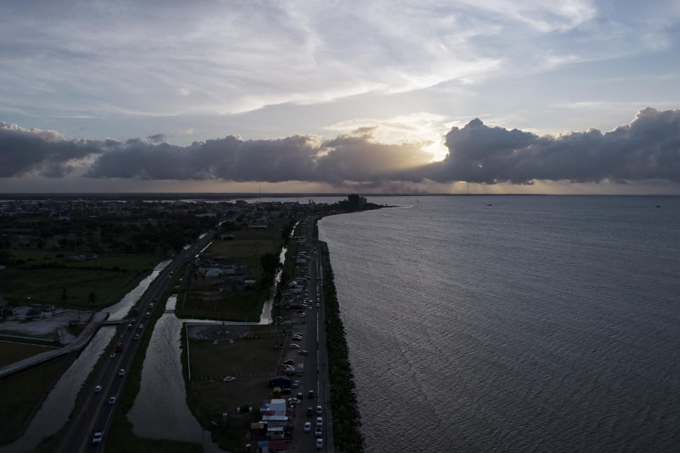 View of the seawall during sunset in Georgetown, Guyana, Wednesday, April 19, 2023. The centuries-old sea defense system was created by the Dutch during the colonial era. (AP Photo/Matias Delacroix)