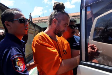 Police escort British man David Taylor, 33 (C), arrested over the killing of a policeman, into a vehicle at a police station in Denpasar, on the Indonesian resort island of Bali, August 23, 2016 in this photo taken by Antara Foto. Antara Foto/Wira Suryantala/via REUTERS