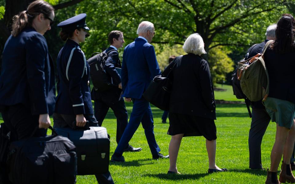 The president walks towards Marine One, his helicopter, surrounded by staff in Washington DC