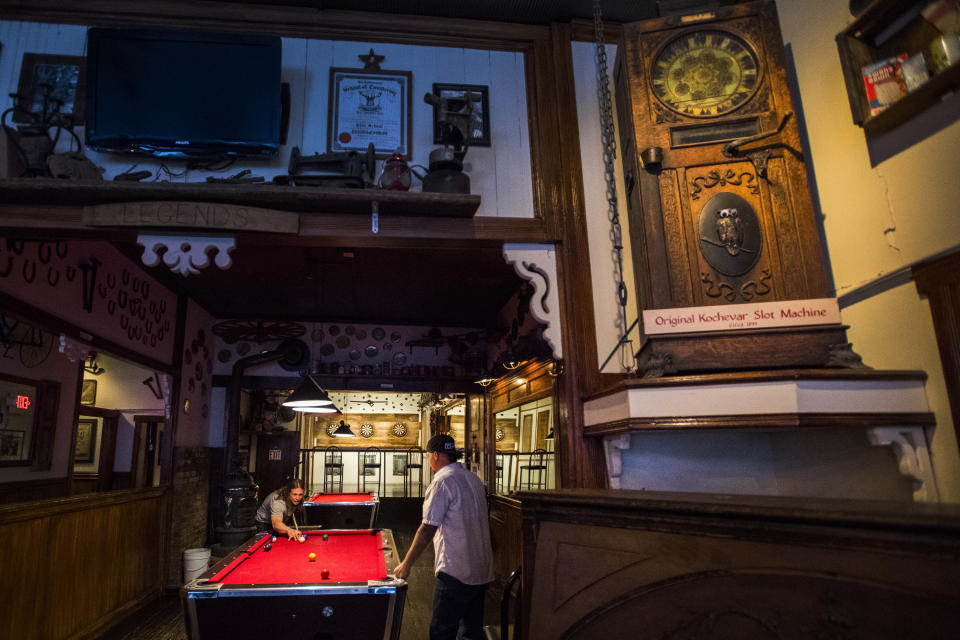 In this Dec. 4, 2018 photo, Joshua Petersen, left, and Tony Pitsikos play a game of pool in the historic Kochevar's Saloon & Gaming Hall in Crested Butte, Colorado. When the small county in the Colorado mountains banished everyone but locals to blunt the spread of coronavirus, an unlikely outsider raised a fuss: Texas Attorney General Ken Paxton, who called it an affront on Texans who own property there and pressed health officials to soften the rules. "The banishment of nonresident Texas homeowners is entirely unconstitutional and unacceptable," Paxton said April 9, 2020, when his office fired off a letter to authorities in Gunnison County. (Christian Murdock/The Gazette via AP, File)