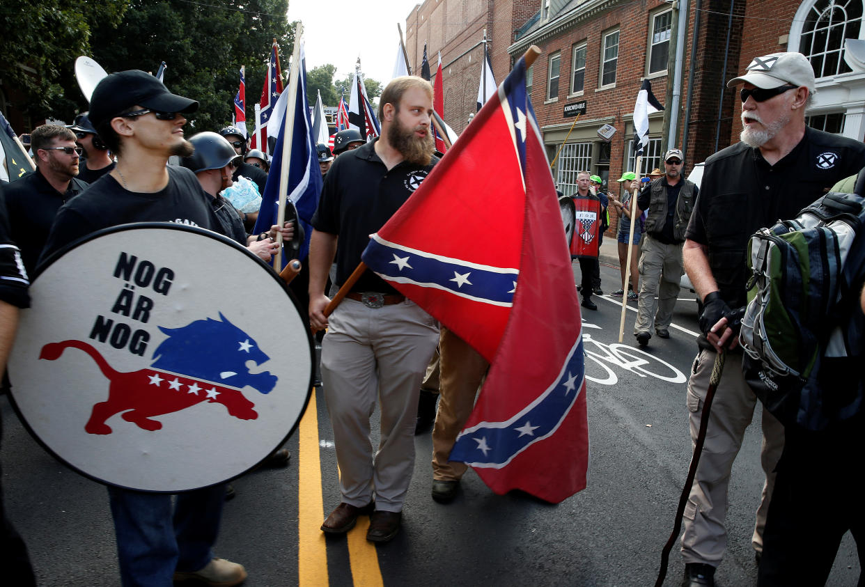 White supremacists carry a shield and Confederate flag as they arrive at a rally in Charlottesville, Va., Aug. 12, 2017. (Photo: Joshua Roberts/Reuters)