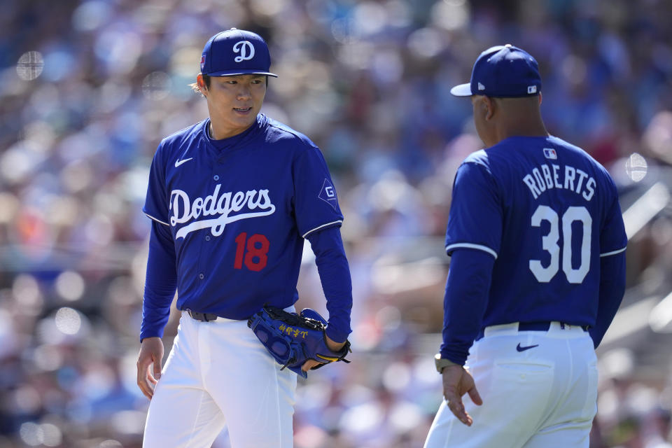 Los Angeles Dodgers manager Dave Roberts (30) arrives at the mound to removed starting pitcher Yoshinobu Yamamoto (18) during the fifth inning of the team's spring training baseball game against the Seattle Mariners on Wednesday, March 13, 2024, in Phoenix. (AP Photo/Ross D. Franklin)