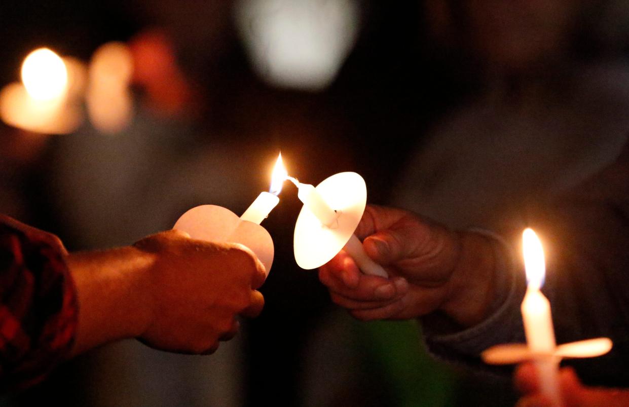 Attendees light candles at the Take Back the Night rally on Oct. 22, 2019, in downtown Lancaster, Ohio. The rally was intended to raise community awareness about human trafficking, domestic violence, rape and assault.