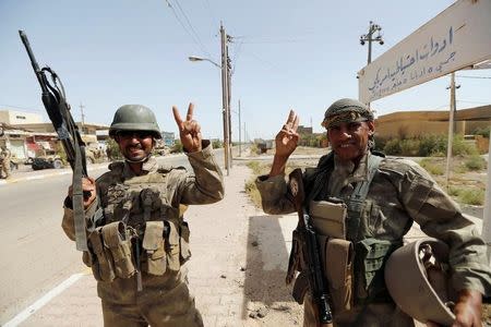 Iraqi soldiers gesture in center of Falluja, Iraq, June 17, 2016. REUTERS/Thaier Al-Sudani