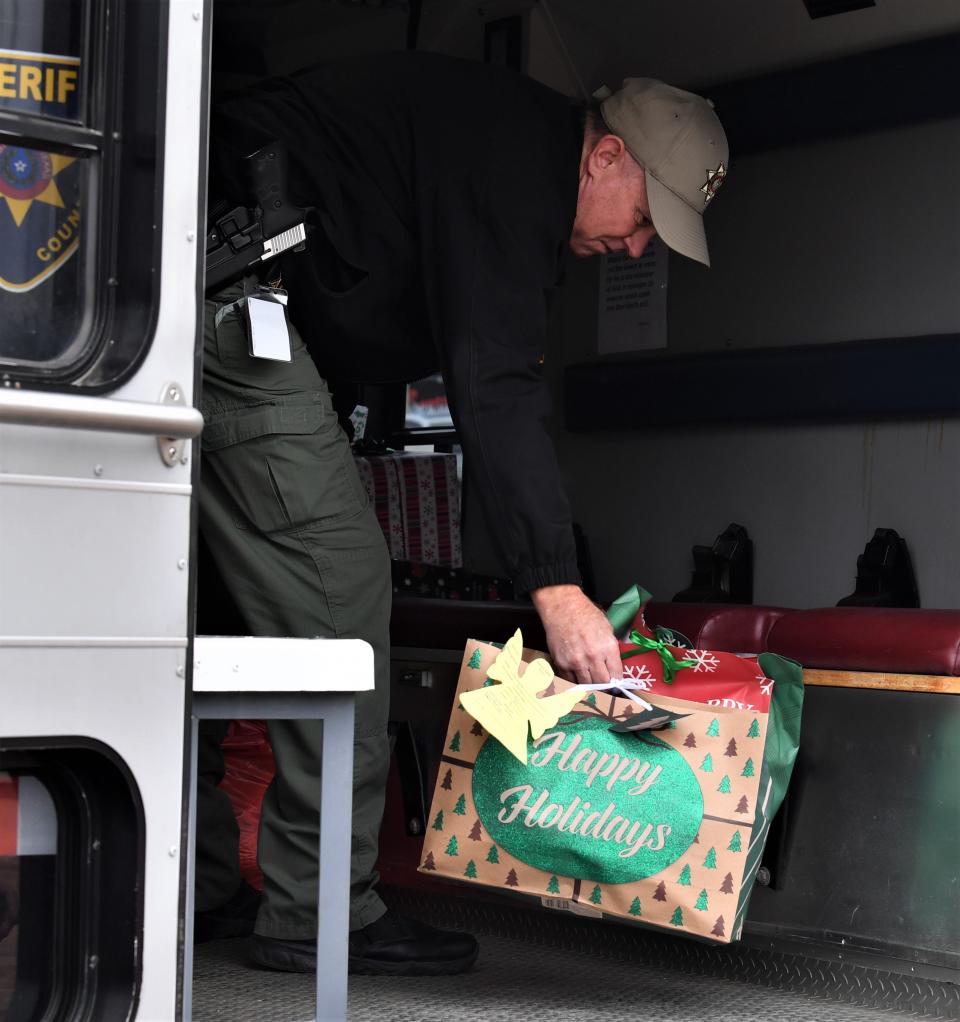 Wichita County Sheriff's Office Captain Alan Boyd unloads gifts during the Angel Tree Program delivery Wednesday.