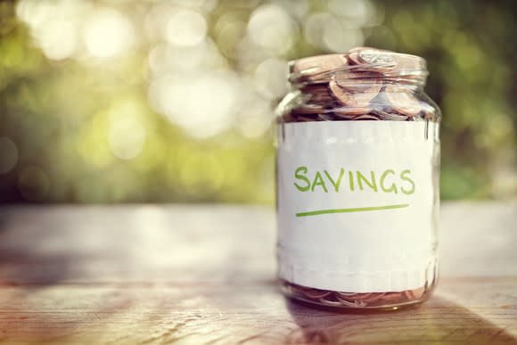 Jar labeled savings filled to the top with coins.