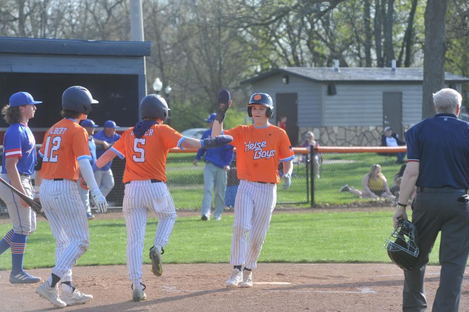 Galion's Kael Longwell high fives Allen Carver after scoring a run.