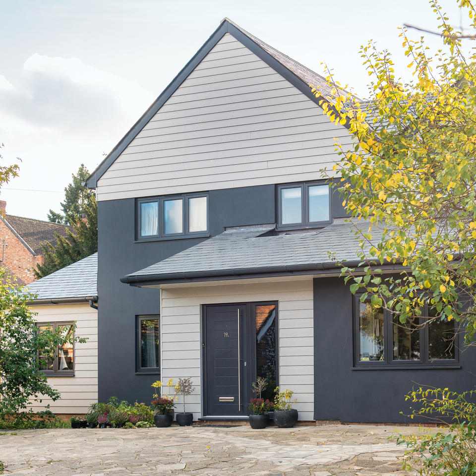 Exterior of a modern detached house with grey cladding and a paved driveway