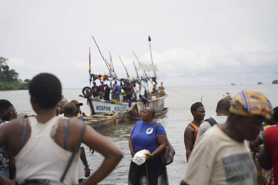 Fishmongers from Limbe, Cameroon, and neighboring communities wait at the shore for fishing boats to arrive with their catch at the shore on Limbe, on April 12, 2022. In recent years, Cameroon has emerged as one of several go-to countries for the widely criticized “flags of convenience” system, under which foreign companies can register their ships even though there is no link between the vessel and the nation whose flag it flies. But experts say weak oversight and enforcement of fishing fleets undermines global attempts to sustainably manage fisheries and threatens the livelihoods of millions of people in regions like West Africa. (AP Photo/Grace Ekpu)